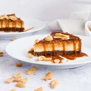Dieses Bild zeigt eine Nahaufnahme eines Stücks Peanutbutter Cheesecakes mit Karamellsauce