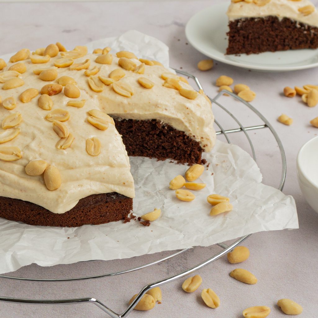 Dieses Bild zeigt einen Schokoladenkuchen mit einem cremigen Frosting aus Sahne, Quark und Erdnussbutter